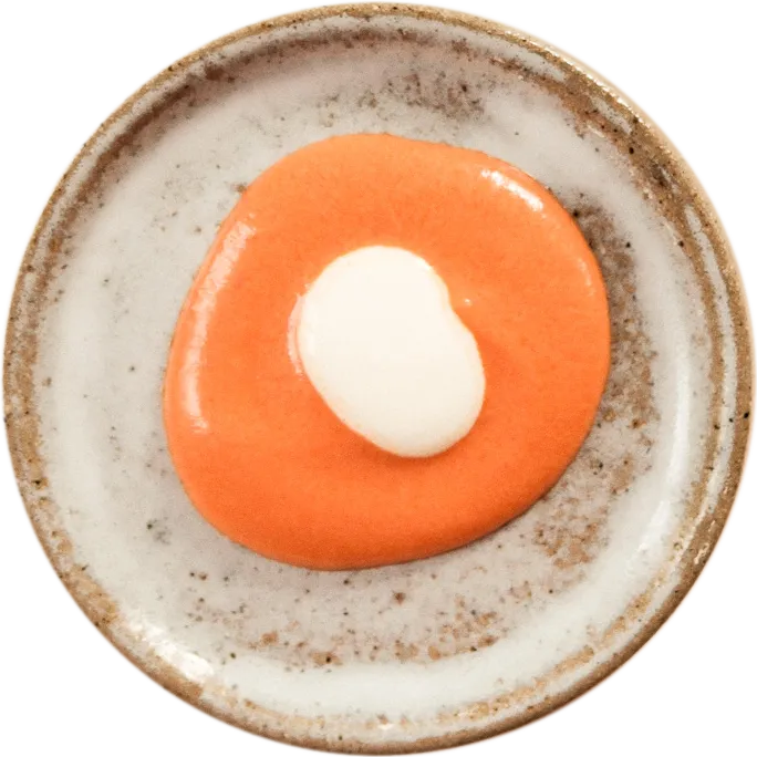 Coupelle en grès vue du dessus, sauce orange et crème
