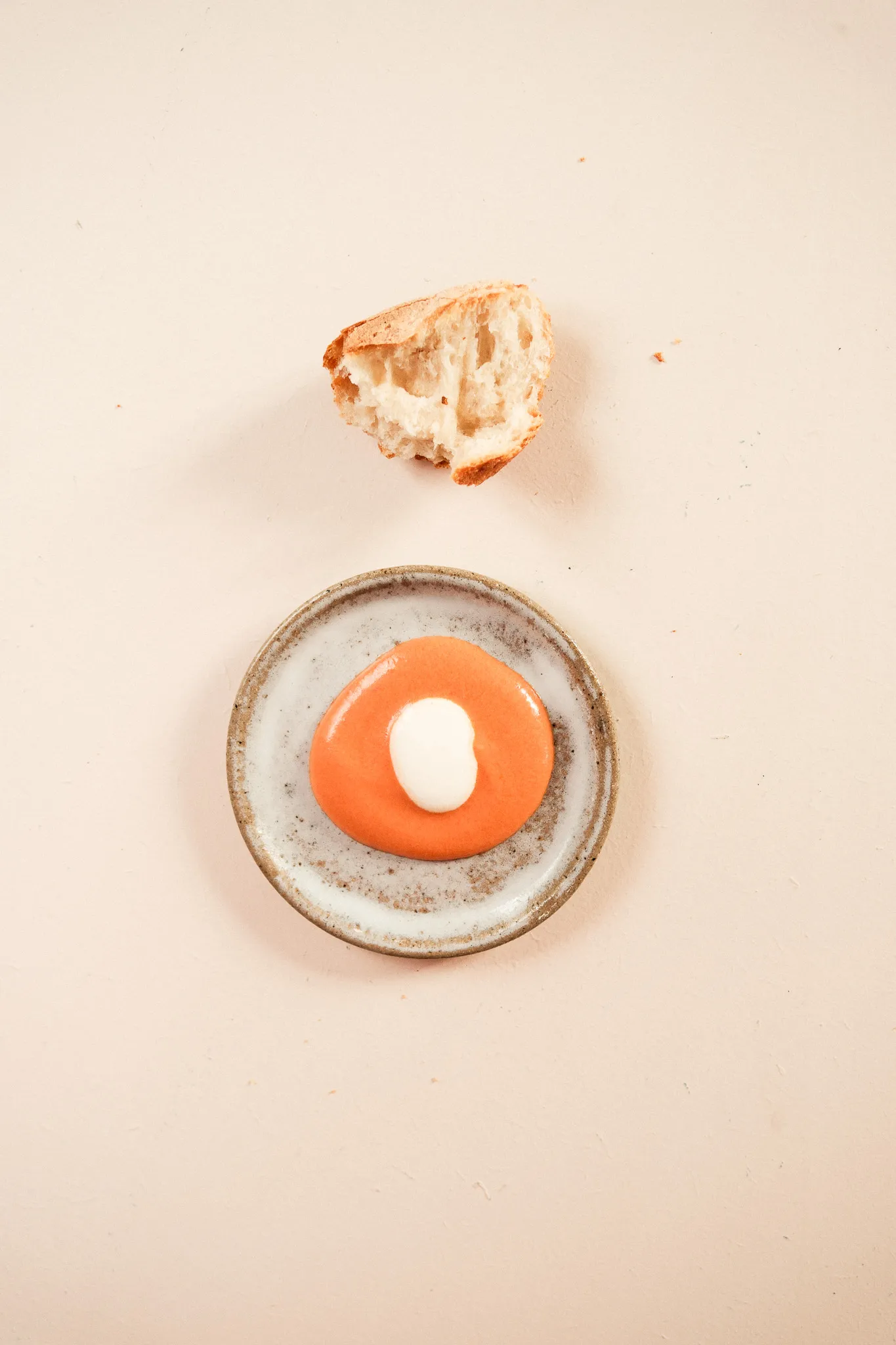 Coupelle de sauce orange et crème, morceau de pain